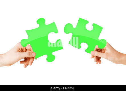 Close up of couple mains avec des pièces de puzzle vert Banque D'Images