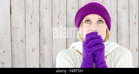 Image composite de jeune femme portant des gants à la recherche vers le haut Banque D'Images
