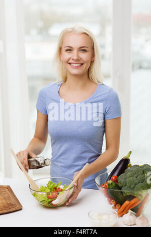 Smiling woman la cuisson de légumes grillés à la maison Banque D'Images