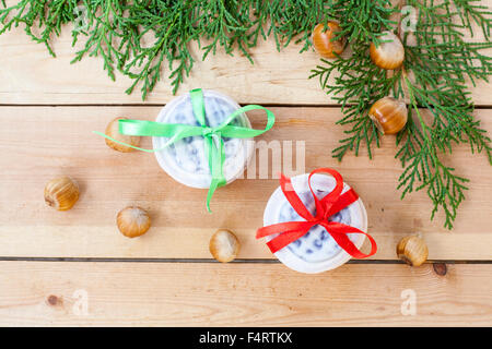 Les biscuits de Noël avec des rubans, pommes, noix, pommes de pin, la cannelle et le thuya vert direction sur une table en bois. Banque D'Images