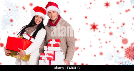 Image composite du jeune couple avec de nombreux cadeaux de Noël Banque D'Images