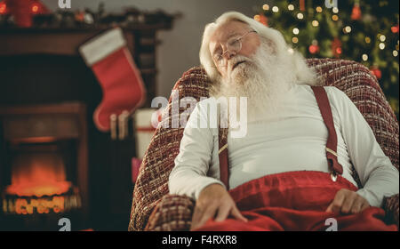 Le père noël la sieste sur le fauteuil Banque D'Images