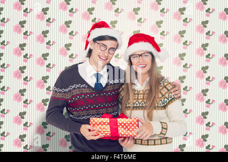 Image composite de hipster geek couple holding present Banque D'Images