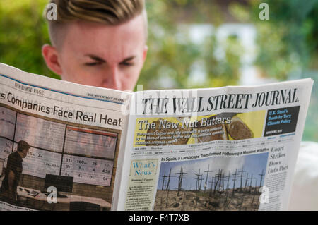 Un jeune homme professionnel de la lecture du Wall Street Journal Banque D'Images