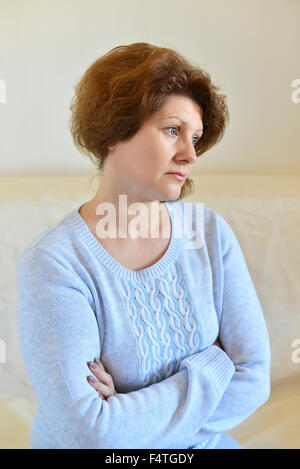 Femme triste à loin à la maison dans la salle de séjour Banque D'Images