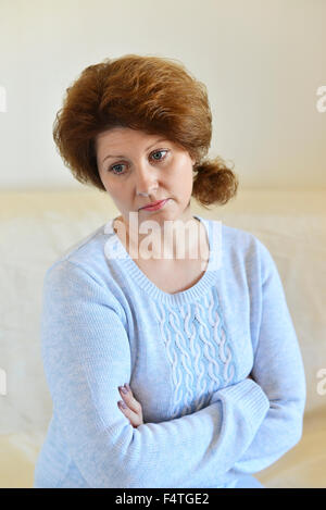 Femme triste à loin à la maison dans la salle de séjour Banque D'Images