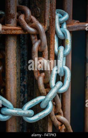Moody concept métal rouillé portes sont verrouillées par des liens avec l'ancienne chaîne de patine autour de barres de fer symbolisant pas de s'échapper ou d'entrée Banque D'Images