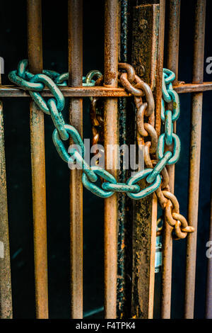 Moody concept métal rouillé portes sont verrouillées par des liens avec l'ancienne chaîne de patine autour de barres de fer symbolisant pas de s'échapper ou d'entrée Banque D'Images