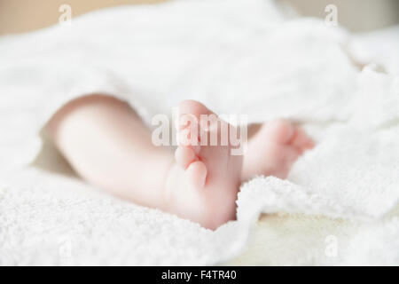 Pieds de bébé sur couvre-lit blanc. Les orteils. Banque D'Images