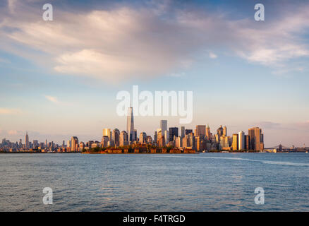 Gratte-ciel de New York et du quartier financier de Lower Manhattan à sunset light avec Battery Park et Ellis Island. New York City Banque D'Images