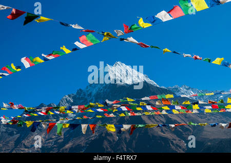 Drapeaux de prière bouddhiste en face de la montagne au-dessus de Namche Bazar Kangtega (3,440 m), la base pour le trekking et l'alpinisme dans la Banque D'Images