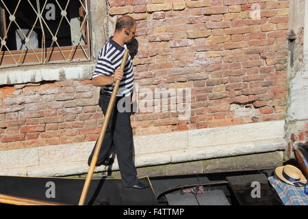 Un gondolier oriente sa gondole à travers Venise, Italie Banque D'Images