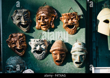 Masques Grecian hanging on a market stall dans le soleil l'après-midi. Banque D'Images