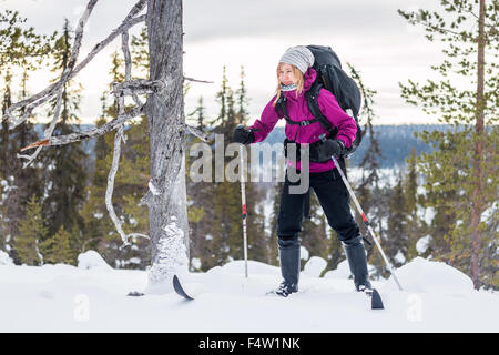 Jeune femme avec un sac à dos de ski en Laponie. Banque D'Images