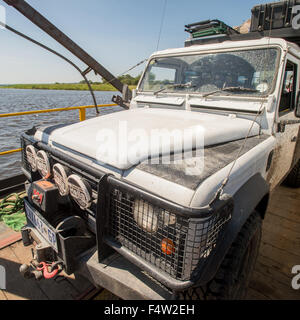 Kasane, Botswana - livre blanc de 1994 Land Rover Defender 110 sur barge traversant la rivière. Banque D'Images