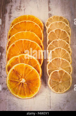 Vintage photo, tranches de citron et d'orange frais ou sec allongé sur vieux fond rustique en bois Banque D'Images