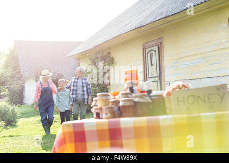 Les grands-parents et petit-fils à marcher vers stand miel rural Banque D'Images