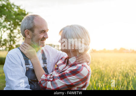 Romantic couple hugging in rural field ensoleillé Banque D'Images