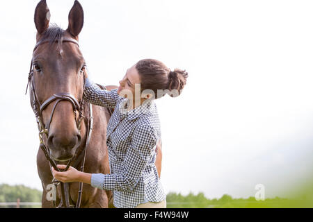 Woman petting horse Banque D'Images