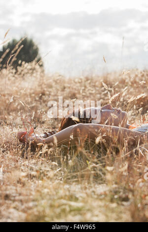 Serene woman sleeping in rural field Banque D'Images