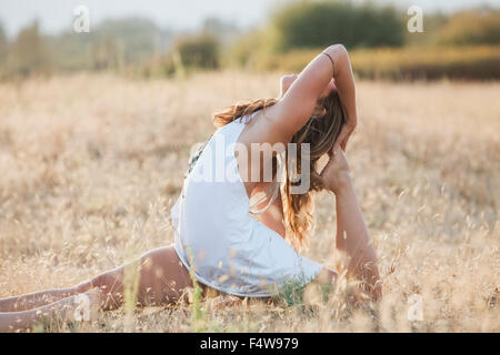 Boho femme en royal king pigeon poser à sunny rural field Banque D'Images