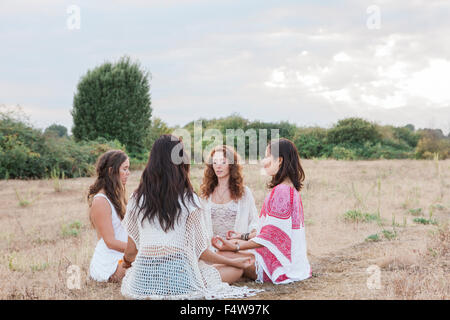 Les femmes Boho méditant dans circle in rural field Banque D'Images