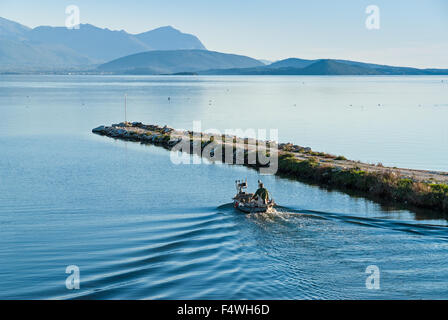 Un pêcheur dans son bateau en bois traditionnel quitte le port, aller au travail le 10 novembre 2013 dans le golfe d'Ambracie, Grèce. Banque D'Images