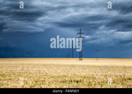 Immense nuage sur un champ de blé et de pylônes électriques dans la distance, République Tchèque Banque D'Images