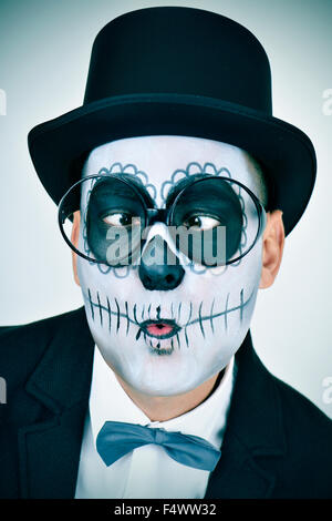 Portrait d'un homme à la mexicaine comté maquillage, portant veste, noeud papillon, lunettes et chapeau, louchant Banque D'Images