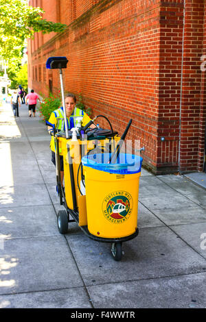 Femme adulte poussant un chariot de nettoyage de rue dans les rues de Portland, Oregon Banque D'Images