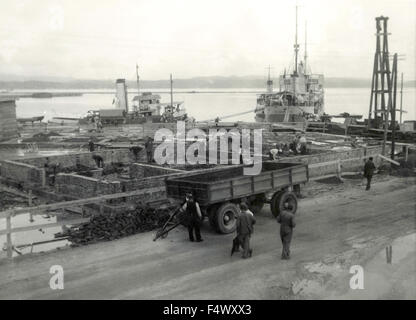 Bateau à moteur de Dalmatie en port à côté de la construction d'une base militaire italienne à Durres, Albanie Banque D'Images