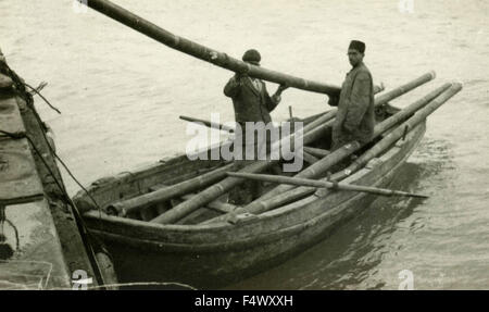Deux travailleurs sur un petit bateau au cours de la construction du port de Durres, Albanie Banque D'Images