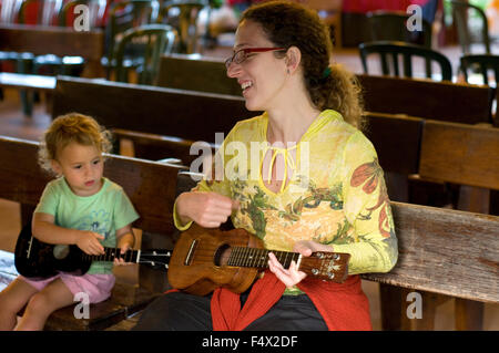 Mère et fille jouer ukulélé en centre culturel polynésien. O'ahu. Hawaii. Le Centre Culturel polynésien (PCC) est un Poly Banque D'Images