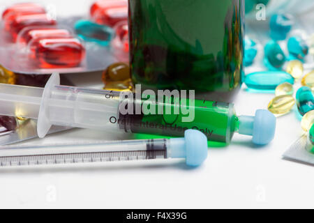 Close-up de vert bouteille avec un médicament contre la toux et seringues orales cold remedy capsules. Banque D'Images