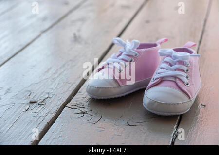 Cute baby girl pink sneakers close up sur fond gris Banque D'Images