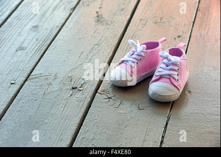 Cute baby girl pink sneakers close up sur fond gris Banque D'Images