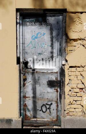 Graffiti sur mur délabré en porte métallique n district Malasana, Madrid, Espagne Banque D'Images