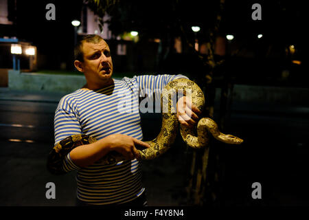 Un Israélien est titulaire d'un boa constrictor, également appelé le boa à queue rouge ou le serpent boa commun à Jaffa Street West Jérusalem Israël Banque D'Images