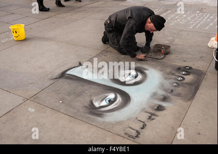 Artiste de rue et esquisses sur le trottoir en dalles de Trafalgar de croquis à la craie le visage et les yeux le marquage d'un patch Banque D'Images