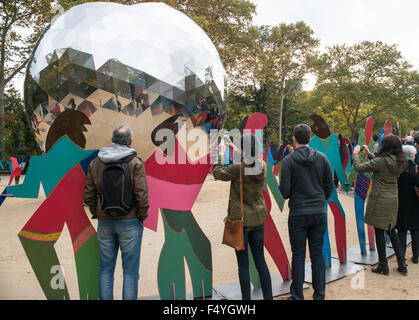 New York, États-Unis. 24 Oct, 2015. Les spectateurs de l'événement prenez des photos entre les 70 chiffres de l'Gabarron métal installation.Pour commémorer le 70e anniversaire de la Charte des Nations Unies, l'Organisation des Nations Unies et les fonctionnaires de la ville de New York a rejoint pour inaugurer l'ouverture de Cristobal Gabarron's installation sculpturale intitulée 'Univers éclairé :''une sphère métallique réfléchissante entouré par un anneau qui se chevauchent de la vie aux couleurs vives, grandeur se tenant la main. © Albin Lohr-Jones/Pacific Press/Alamy Live News Banque D'Images