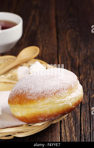 Berliner donut avec tasse de café chaud sur la table en bois foncé Banque D'Images