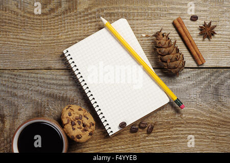 Ouvrir le bloc-notes et tasse de café avec des biscuits au chocolat sur la vieille table en bois. Vue d'en haut Banque D'Images