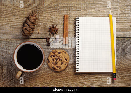 Ordinateur portable ouvert et une tasse de café chaud avec de délicieux cookies au chocolat sur la vieille table en bois. Vue d'en haut Banque D'Images