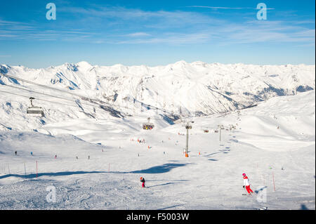 Vue vers le bas d'une piste de ski avec des skieurs et télésiège sur les montagnes Banque D'Images