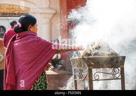 La femme en face de l'encense herbal gravure stupa boudnath Banque D'Images