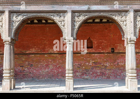 Piliers en pierre sculpté en face d'un mur rouge dans les collines au-dessus du temple de Pashupatinath Banque D'Images