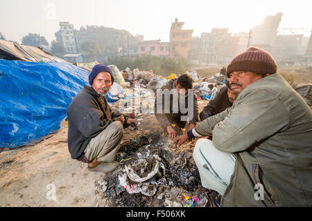 Les gens de basse caste assis autour d'un feu sur le dépotoir à bhagmati river au milieu de la ville Banque D'Images