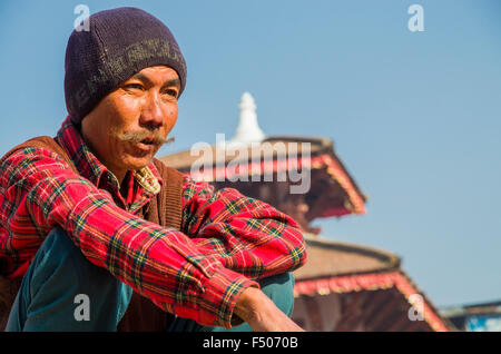 Portrait d'un homme avec chapeau, assis, à l'arrière du toit du temple Banque D'Images