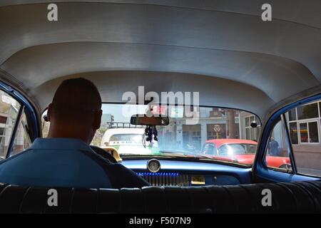 Vision du conducteur et un tableau de bord à partir de la banquette arrière, assis dans la circulation dans un taxi La Havane Cuba vintage Banque D'Images