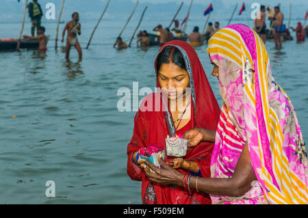2 femmes priant au début de matinée le Sangam, le confluent des fleuves Ganges, yamuna et saraswati, à kumbha mela Banque D'Images